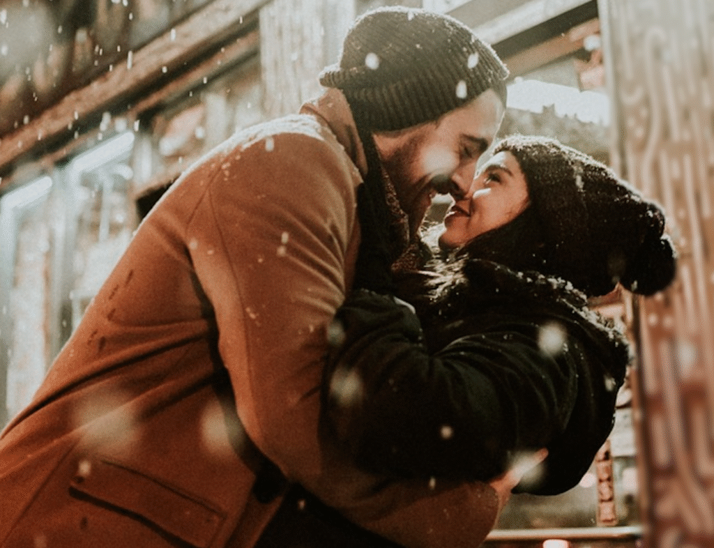 Couple embracing in the snow, finding emotional connection during the winter season in Coquitlam.