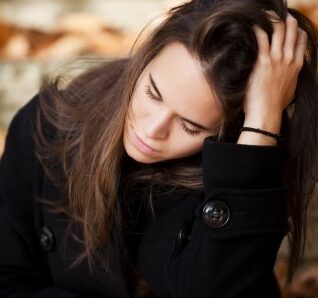Overwhelmed young lady running hand through hair